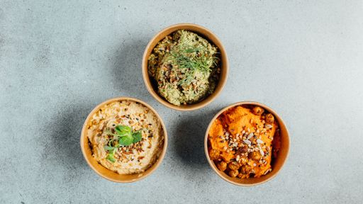 A top view of delicious vegan dishes on a gray table