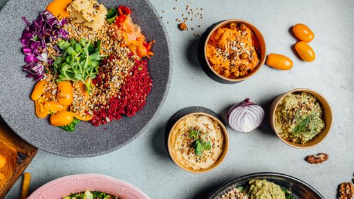 A top view of delicious vegan dishes on a gray table