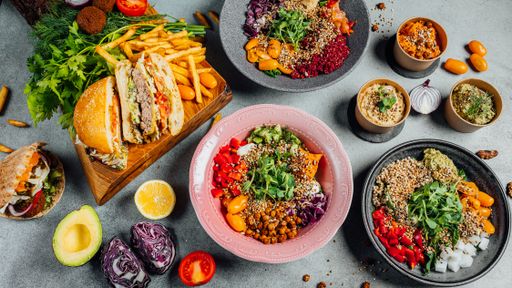 A top view of delicious vegan dishes on a gray table