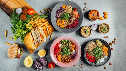 A top view of delicious vegan dishes on a gray table