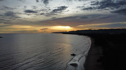 Beautiful shining golden sunset reflected on surface of the undulating ocean on summer evening on coast of Bayawan city.