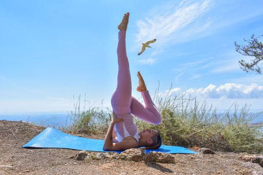 A sporty female doing exercises in an outdoor park dressed in pink