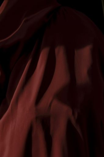 A vertical shot of a red textile with shadows. Will work perfectly as a background image