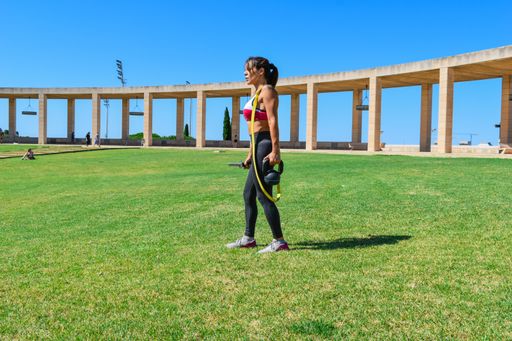 A sexy young female wearing sportswear exercising in a park