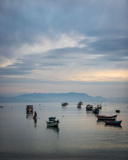A vertical shot of a port with boats at sunset