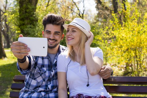 A closeup shot of a young attractive couple taking a happy selfie in a park