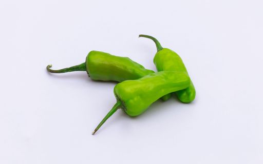A closeup shot of green chili peppers isolated on white background
