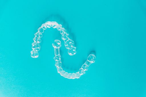 A top view of transparent aligners isolated on a blue background