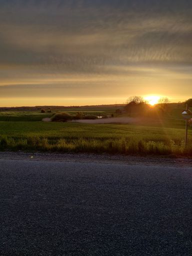 A vertical shot of a beautiful vibrant sunset in the sky in a rural area