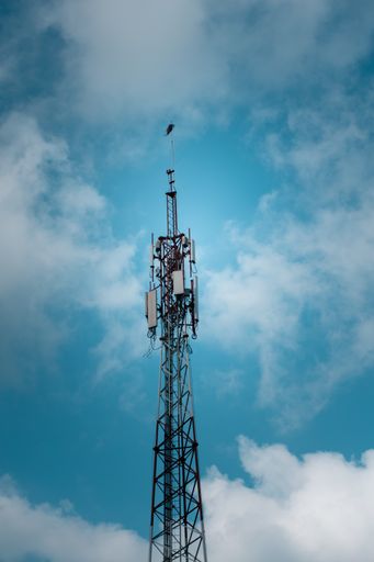 A low angle vertical shot of a large electric pole on a cloudy blue sky background