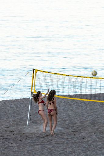 A couple of girls playing beach volleyball on the beach