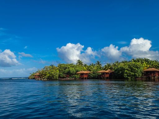 An aerial view of a small tropical island under a blue sky
