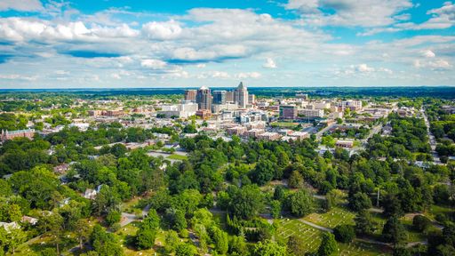 An aerial view of Greensboro city under a blue cloudy sky on a sunny day in summer