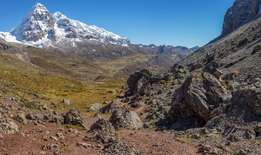 A landscape shot of a beautiful valley surrounded by huge mountains with snowy peaks. Perfect for a wallpaper or a background.