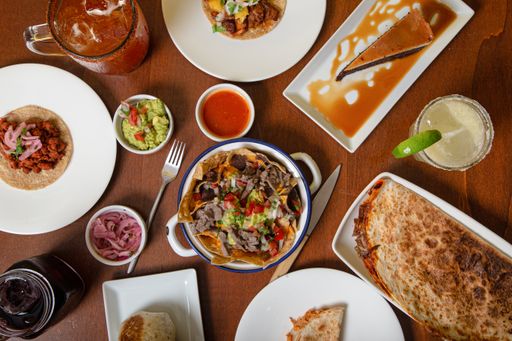 A dinner table with nachos, tacos, and a special dessert