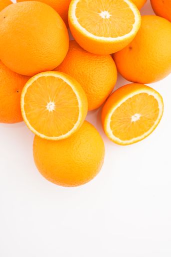 A vertical shot of some cut oranges on a white background.