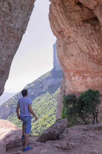 A young tourist man standing between the huge rock formations