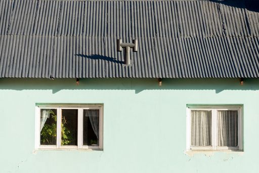 A traditional house with a pastel green colored wall and old windows in  Argentina