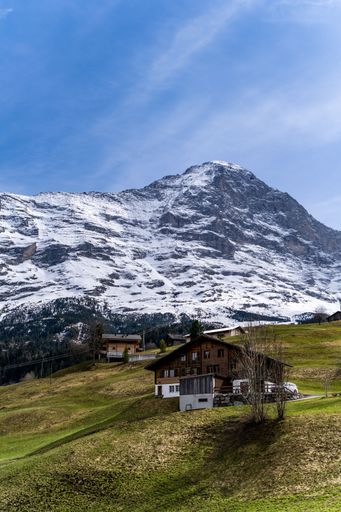 A vertical shot of a wooden cottage near the Lauterbrunnen Mountains in Jungfrau, Switzerland