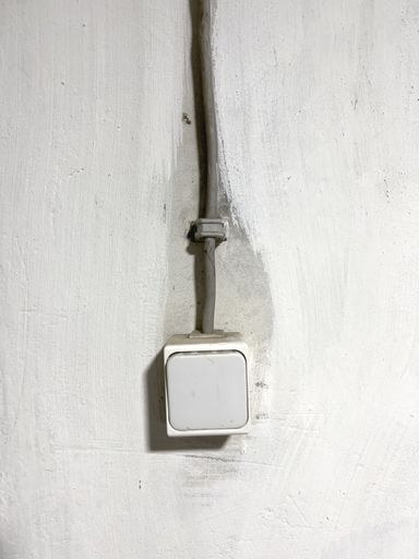 The vertical close-up view of an old light switch on the wall
