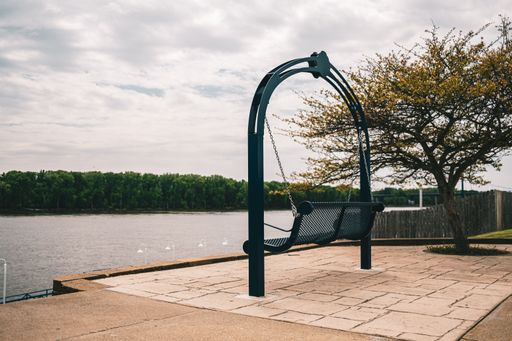 The beautiful black swing hanging from the arch on the riverbank