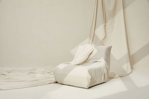 A small white sofa sea in a white room with white cloth