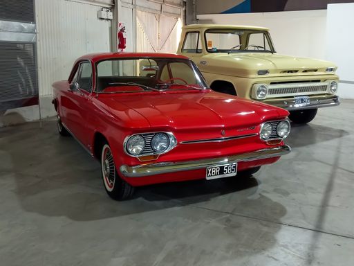 Avellaneda, Argentina - May 7, 2022: Old red Chevrolet Chevy Corvair Monza coupe 1963 in a warehouse. Expo Fierro 2022 classic car show. Copyspace.
