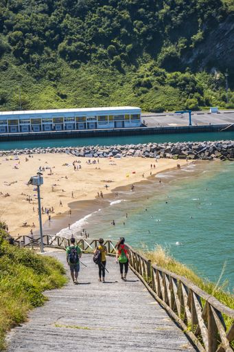 A beautiful shot of a couple on a trekking trip by the sea on Monte Urgul in the city of San Sebastian, Gipuzkoa. Basque Country