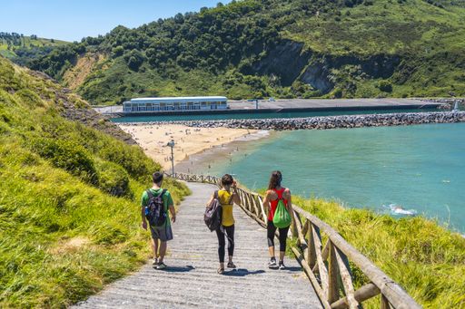 A beautiful shot of a couple on a trekking trip by the sea on Monte Urgul in the city of San Sebastian, Gipuzkoa. Basque Country