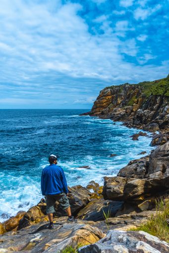 A beautiful shot of a couple on a trekking trip by the sea on Monte Urgul in the city of San Sebastian, Gipuzkoa. Basque Country