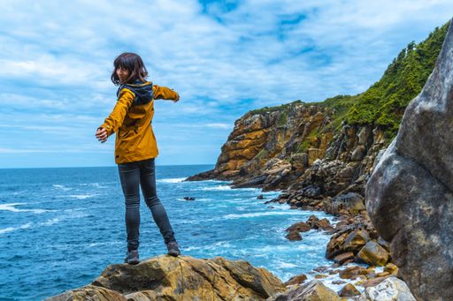 A beautiful shot of a couple on a trekking trip by the sea on Monte Urgul in the city of San Sebastian, Gipuzkoa. Basque Country