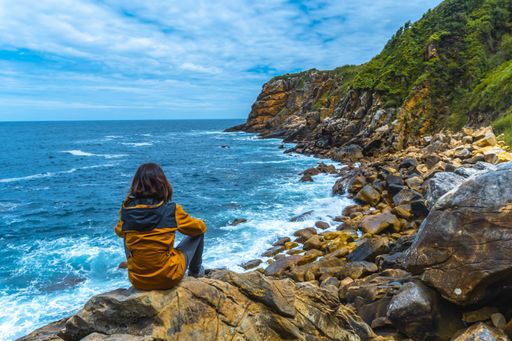 A beautiful shot of a couple on a trekking trip by the sea on Monte Urgul in the city of San Sebastian, Gipuzkoa. Basque Country