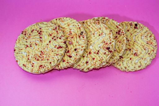 The some round crackers with red marks isolated on the pink background