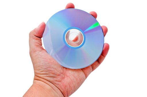 A closeup shot of a person's hand holding a compact disc isolated on a white background