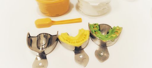 A closeup shot of dental instruments - prosthetics, invisalign, anesthesia syringe, silicone
