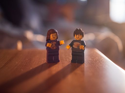 A selective focus shot of the small toy figurines on a wooden surface under a sunlight