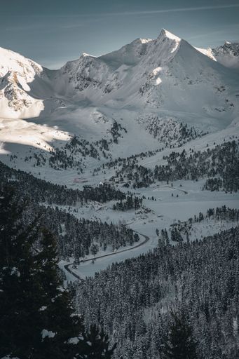 A vertical shot of mountains covered in snow during the day