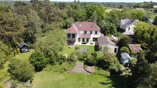 An aerial view of a beautiful English country houses surrounded by greenery