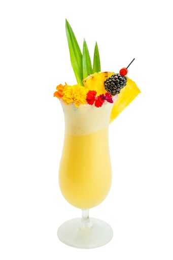 Pina colada cocktail decorated with fruits and edible flowers isolated on white background.