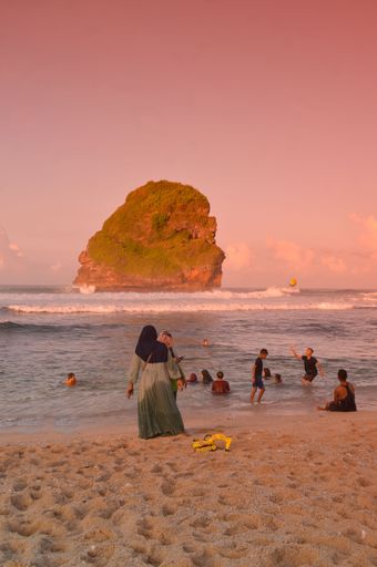 beach landscape with people relaxing on the beach. 
Eid holiday after the pandemic is over on the coast of Goa China, Malang, East Java
