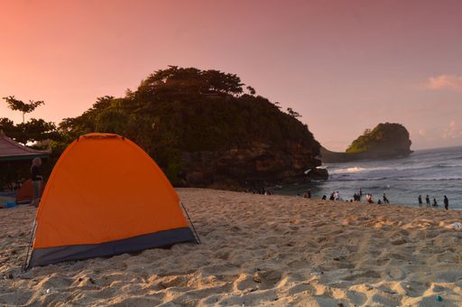 silhouette of a tent on the beach at sunrise. 
Sunrise on the coast of Goa China, Malang, East Java