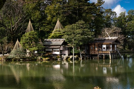 Traditional Japanese buildings reflected in the central pond of Kenrokuen, one of Japan's premier traditional gardens. Kanazawa, Japan.