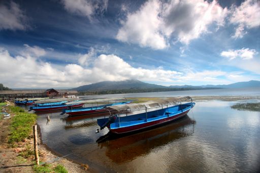 A horizontal shot of boats in Lake Batur, in Bali, Indonesia under the breathtaking cloudy sky