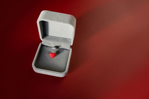 A closeup shot of a red heart-shaped pin in red box