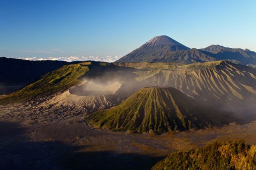 A horizontal shot of the beautiful Bromo volcano covered in fog under the clear sky