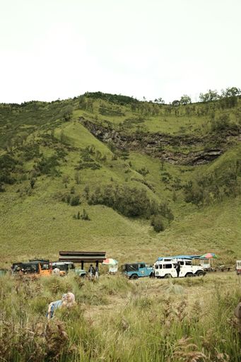 A group of tourist cars near the green hill