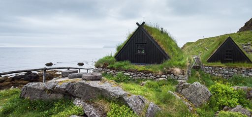A horizontal shot of beautiful cabins on the shore near the sea in Iceland during daytime