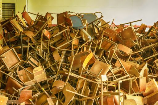 A room full of old broken wooden chairs