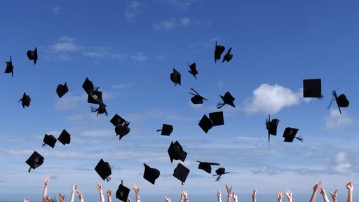 Many graduation caps in the air during the graduation celebration
