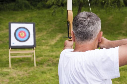 A man holding the arrow and playing the target archery game